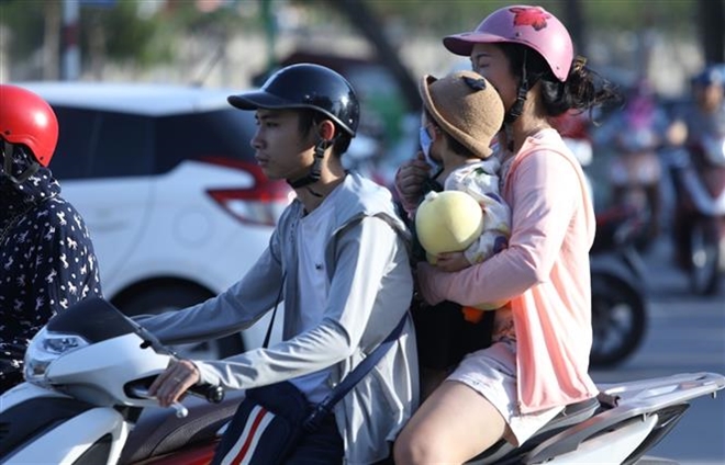 Trong ảnh: Người dân Thủ đô tham gia giao thông gặp nhiều khó khăn khi nhiệt độ ngoài trời ở ngưỡng 40 độ C. Ảnh: Văn Điệp - TTXVN