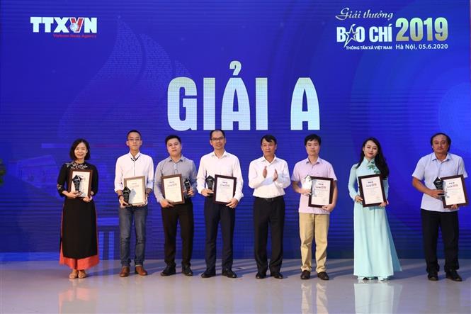 Trong ảnh: Tổng giám đốc TTXVN Nguyễn Đức Lợi trao giải A cho các tác giả đoạt giải. Ảnh: Minh Quyết - TTXVN