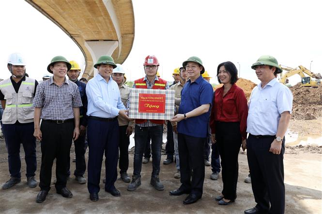 Trong ảnh: Bí thư Thành ủy Hà Nội Vương Đình Huệ tặng quà cán bộ, công nhân tại Dự án Đầu tư xây dựng hoàn chỉnh theo quy hoạch nút giao đường Vành đai 3 với đường ô tô cao tốc Hà Nội - Hải Phòng, huyện Gia Lâm. Ảnh: Văn Điệp - TTXVN