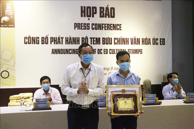 Phó Chủ tịch UBND tỉnh An Giang Lê Văn Nưng (bìa trái) trao Bằng khen của UBND tỉnh kèm Logo cho đại diện của họa sĩ Nguyễn Du tác giả của bộ tem Văn hóa Óc Eo. Ảnh: Công Mao -TTXVN