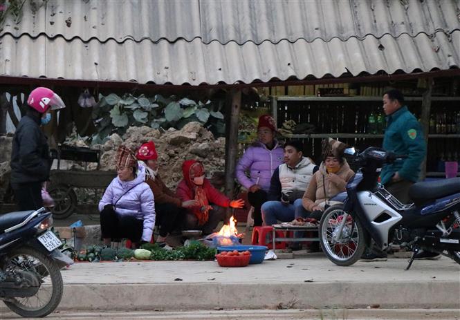 Trong ảnh: Tại phường Thanh Trường (thành phố Điện Biên Phủ), nhiều tiểu thương tụ tại điểm chợ cóc cạnh quốc lộ 12 tập sưởi ấm bên đống lửa. Ảnh: Xuân Tiến-TTXVN