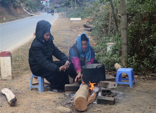 Trong ảnh: Người dân sinh sống dưới chân đèo Pha Đin, cạnh quốc lộ 6 đốt lửa sưởi ấm, chống chọi với giá lạnh. Ảnh: Xuân Tiến-TTXVN