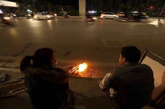 Giữa cái lạnh tê tái, người Hà Nội co ro đốt lửa sưởi ấm trên phố. Ảnh: TTXVN