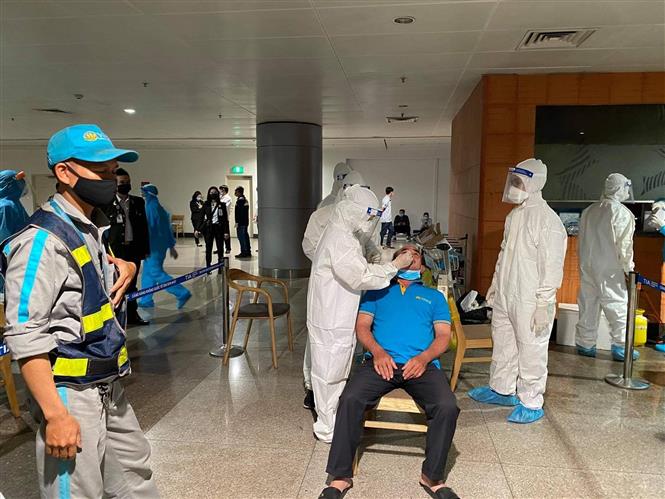 Trong ảnh: Nhân viên y tế lấy mẫu xét nghiệm cho người làm việc tại sân bay Tân Sơn Nhất ngày 6/2. Ảnh: TTXVN phát