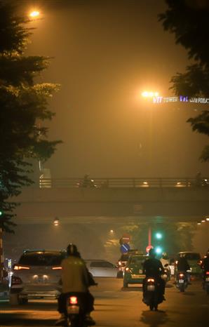 Sáng 17/11, sương mù đặc trắng, tầm nhìn xa hạn chế gây khó khăn cho người tham gia giao thông. Ảnh: Thành Đạt - TTXVN